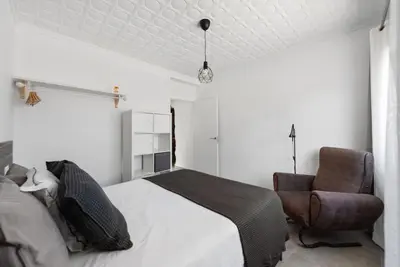 a bedroom with a bed and a chair at Bombonera 2 Jacuzzi in Catadau