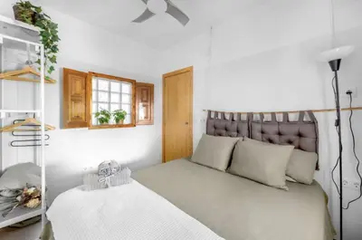 a bedroom with a bed with a headboard and a window at Bombonera 2 Jacuzzi in Catadau
