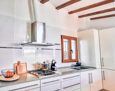 a kitchen with white cabinets and a stove top oven at Bombonera 2 Jacuzzi in Catadau