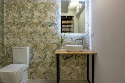 a bathroom with a toilet and a sink and a mirror at Lore Loft Valencia in Valencia