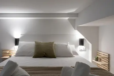 a bedroom with a large bed with white walls at Lore Loft Valencia in Valencia