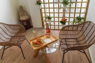 a room with a glass table with a bottle of wine and two chairs at Studio chic avec terrasse, lumineux et calme 1 in Valencia