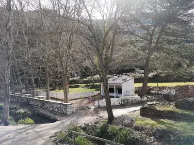 a building in a park with trees and a road at Casa Rural Ana Maria Ain in Ahín