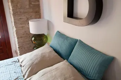 a couch with two pillows and a lamp in a room at BUBUFLATS Mossén in Valencia