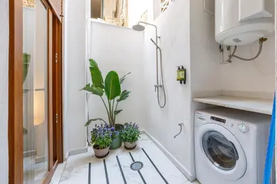 a laundry room with a washing machine and potted plants at Artisan Haven: El Cabanyal Oasis in Valencia