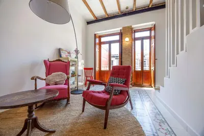 a living room with two chairs and a table at Artisan Haven: El Cabanyal Oasis in Valencia