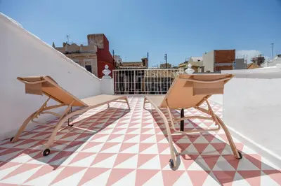 a pair of chairs sitting on top of a roof at Artisan Haven: El Cabanyal Oasis in Valencia