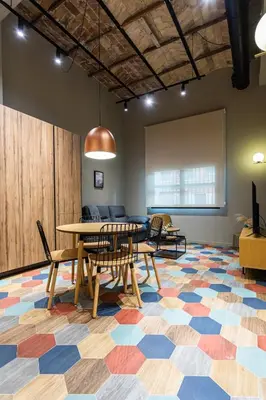 a dining room with a table and chairs on a colorful floor at REINA FLATS VALENCIA Playa in Valencia