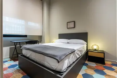 a bedroom with a bed and a table in it at REINA FLATS VALENCIA Playa in Valencia