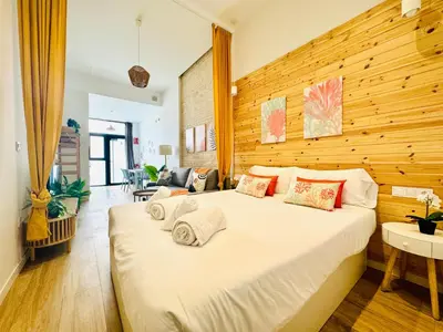 a bedroom with a large white bed with a wooden wall at Beautiful Flat NEXT the BEACH in Valencia
