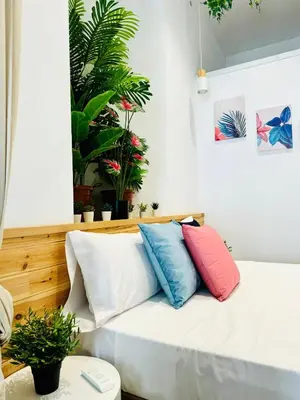 a couch with four pillows on it in a room with plants at Nice & Cozy Flat Close The Beach in Valencia