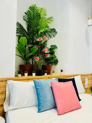 a bed with colorful pillows on it with plants at Nice & Cozy Flat Close The Beach in Valencia