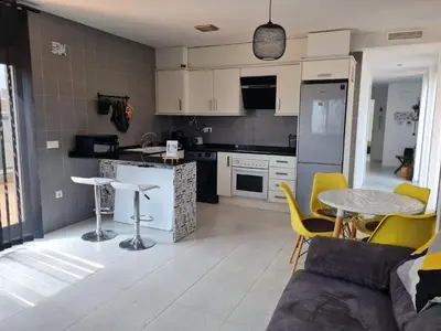 a kitchen and living room with a table and chairs at Attic terrace 360 Moncofa in Moncófar