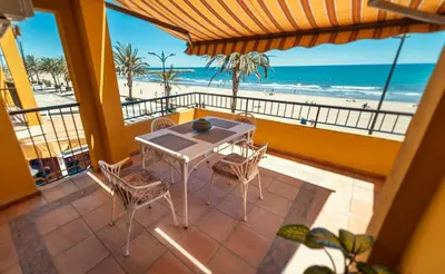 a balcony with a table and chairs and the beach at Apartamento familiar Port-Saplaya in Port Saplaya
