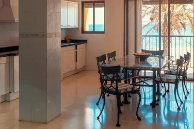 a kitchen and dining room with a table and chairs at Apartamento familiar Port-Saplaya in Port Saplaya
