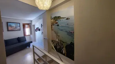 a hallway with a painting of the ocean on the wall at District Key - Lliria, Santisima Sangre in Lliria