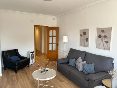 a living room with a couch and a chair at Frente al puerto y junto a la playa del Arenal in Burriana