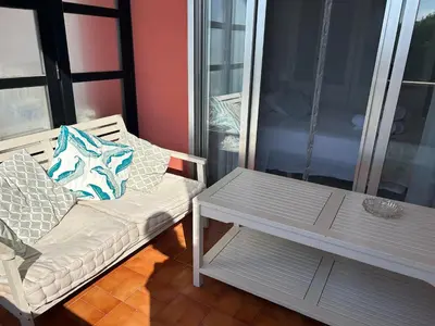 a couch and a coffee table on a balcony at Frente al puerto y junto a la playa del Arenal in Burriana
