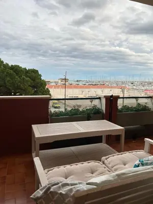 a balcony with a table and a view of a city at Frente al puerto y junto a la playa del Arenal in Burriana