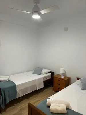 a bedroom with two beds and a ceiling fan at Frente al puerto y junto a la playa del Arenal in Burriana