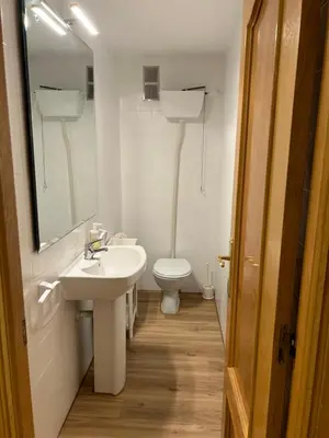 a white bathroom with a sink and a toilet at Frente al puerto y junto a la playa del Arenal in Burriana