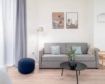 a living room with a couch and a table at Limehome Valencia Carrer de Sant Jacint in Valencia