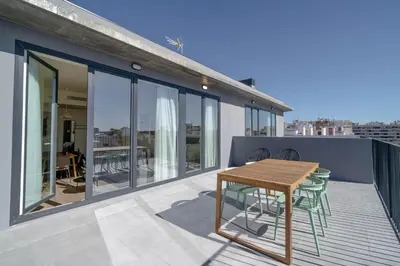 a balcony with a wooden table and chairs on it at Limehome Valencia Carrer de Sant Jacint in Valencia