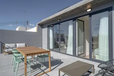 a patio with a table and chairs on a balcony at Limehome Valencia Carrer de Sant Jacint in Valencia