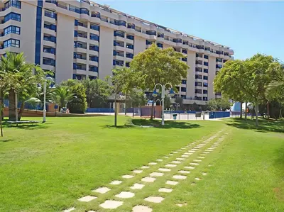 a walkway in a park in front of a building at Apto. luminoso con vistas en playa de La Patacona in Valencia