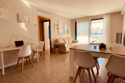 a kitchen and living room with a table and chairs at Apto. luminoso con vistas en playa de La Patacona in Valencia