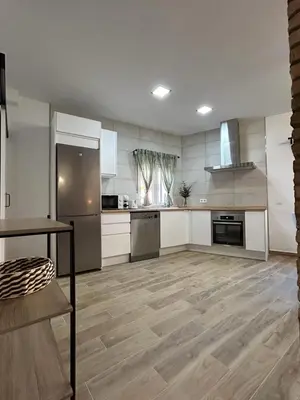 a large kitchen with white cabinets and a wooden floor at CAN´SELMA 1 in Chella