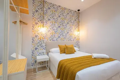 a bedroom with a white bed with a yellow blanket at FLORIT FLATS - The Joaquin Sorolla Station Apartments in Valencia