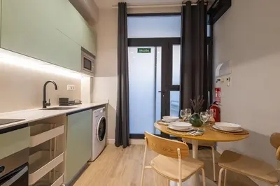 a kitchen and dining room with a table and a sink at FLORIT FLATS - The Joaquin Sorolla Station Apartments in Valencia