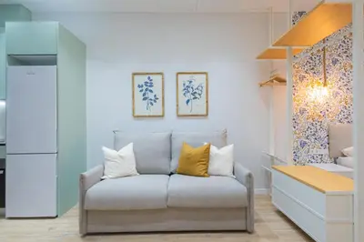 a living room with a couch with yellow pillows at FLORIT FLATS - The Joaquin Sorolla Station Apartments in Valencia