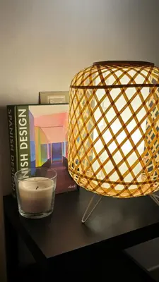 a lamp on a table with a book and a candle at Apto con vistas a la playa de La Patacona in Valencia