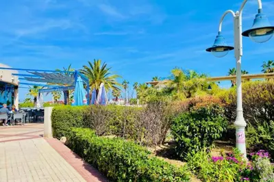 a street light next to a park with palm trees at Apto con vistas a la playa de La Patacona in Valencia