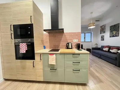 a kitchen with a stove top oven next to a living room at Mestalla Garden in Valencia