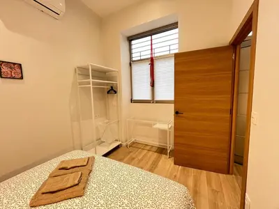 a bedroom with a bed and a wooden door at Mestalla Garden in Valencia