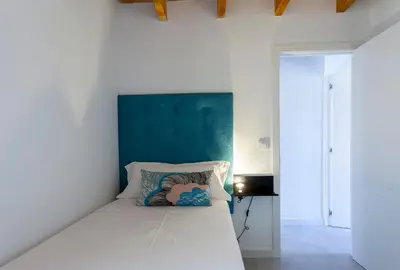 a white bed with a blue headboard in a bedroom at Mediterranean Gem Getaway in Valencia