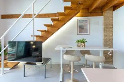 a living room with a table and a staircase at Mediterranean Gem Getaway in Valencia