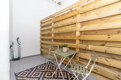 a table and chairs in front of a wooden wall at GuestReady - Valencia's Vibrant Malvarrosa in Valencia