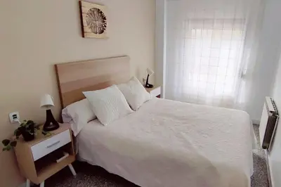 a bedroom with a white bed and a nightstand with a white bedspread at Casa Lola - Con 2 terrazas, ideal para desconectar in Requena