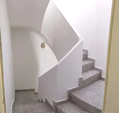 a stairway with a white wall and a stair case at Casa Lola - Con 2 terrazas, ideal para desconectar in Requena