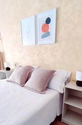 a bedroom with a white bed with two pictures on the wall at Casa Lola - Con 2 terrazas, ideal para desconectar in Requena