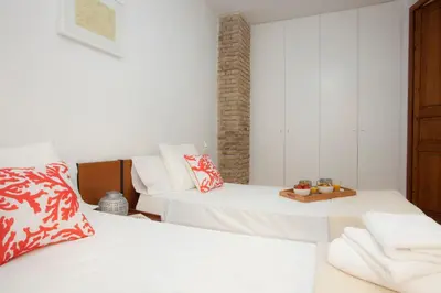 a bedroom with two beds and a table with fruit on it at SingularStays Roteros in Valencia