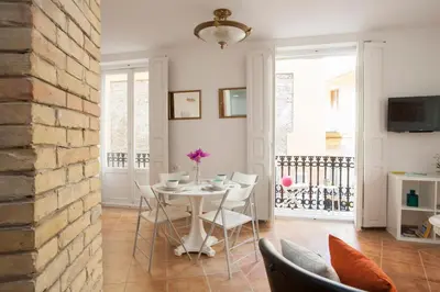 a dining room with a white table and chairs at SingularStays Roteros in Valencia