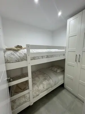 a white room with two bunk beds in it at UIM Mediterraneo ATICO Cendoya Wifi in Puerto de Sagunto