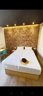 a large bed in a room with a brick wall at Beach Valencia Rooms Late Checkout 14 h free Netflix Tv in Valencia