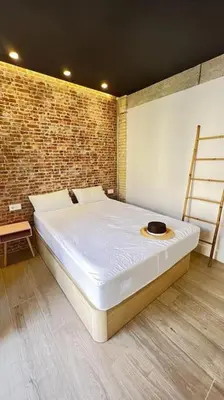 a large bed in a room with a brick wall at Beach Valencia Rooms Late Checkout 14 h free Netflix Tv in Valencia