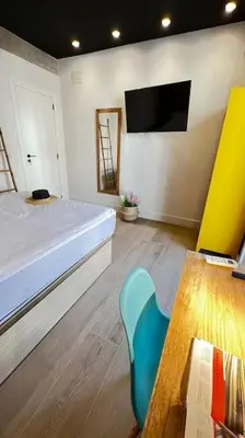 a bedroom with a bed and a table and a chair at Beach Valencia Rooms Late Checkout 14 h free Netflix Tv in Valencia